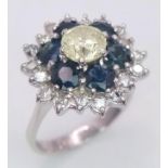 An 18K White Gold Diamond and Sapphire Ring. Central tinted 1ct diamond with sapphire and white