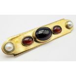 AN EDWARDIAN 15K GOLD BAR BROOCH WITH SEED PEARLS , CARNELIAN AND CENTRAL GARNET . 9.4gms 6cms wide