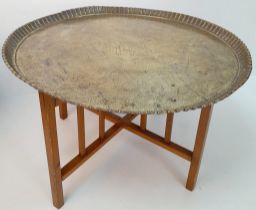 A MIDDLE EASTERN BRASS TOPPED TABLE WITH FOLDING WOODEN LEGS . 52cms TALL 76cms DIAMETER