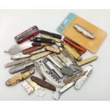 A large group of folding knives, some antique, some modern, some with tools etc.