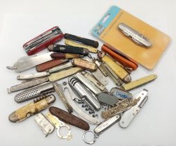 A large group of folding knives, some antique, some modern, some with tools etc.