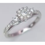 A 9 K white gold ring with a diamond cluster and more diamonds on the shoulders (total 0.41 carats),