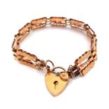 AN ANTIQUE 9K GOLD NICELY PATTERNED GATE BRACELET WITH HEART PADLOCK AND SAFETY CHAIN . 8.1gms
