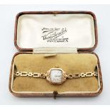 An Antique 9K Gold Ladies Mechanical Watch. 9K gold bracelet and case - 17mm. White patinaed dial.