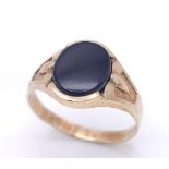 A GENTS 9K GOLD OVAL BLACK ONYX RING WITH DECORATIVE SHOULDERS . 2.8gms size U