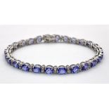 A spectacular 18 K white gold bracelet with oval cut tanzanite gems and round cut diamonds.