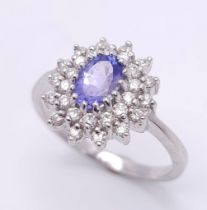 A STUNNING 18K WHITE GOLD DIAMOND & TANZANITE CLUSTER RING, WITH APPROX 0.40CT TANZANITE CENTRE