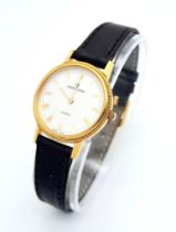 A Gold Plated Universal Quartz Ladies Watch. Black leather strap. Gold plated case - 23mm. White