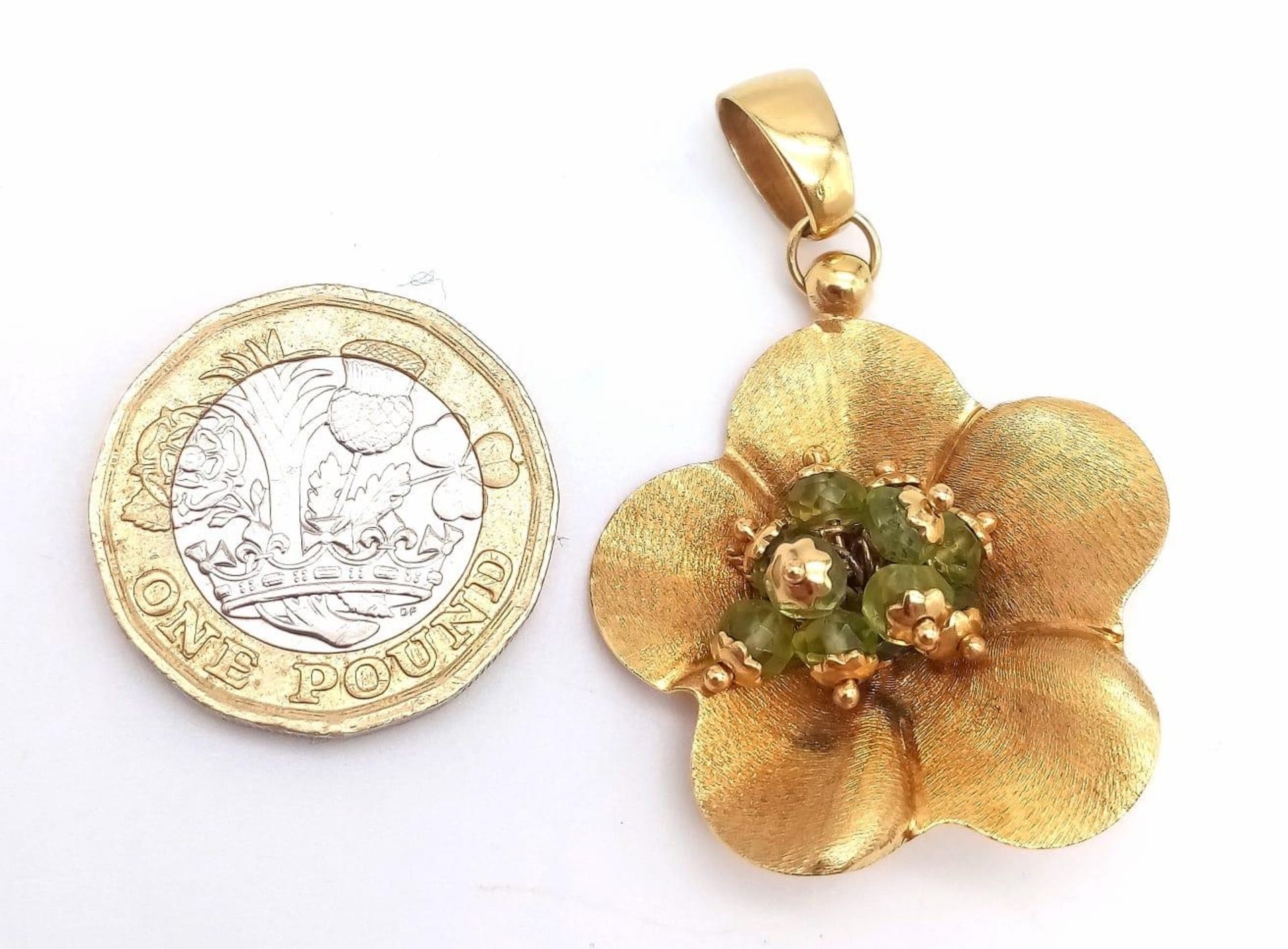 An 18K Yellow Gold Peridot Flower Brooch. Nine peridots amongst golden petals. 5cm. 6.45g total - Image 2 of 4