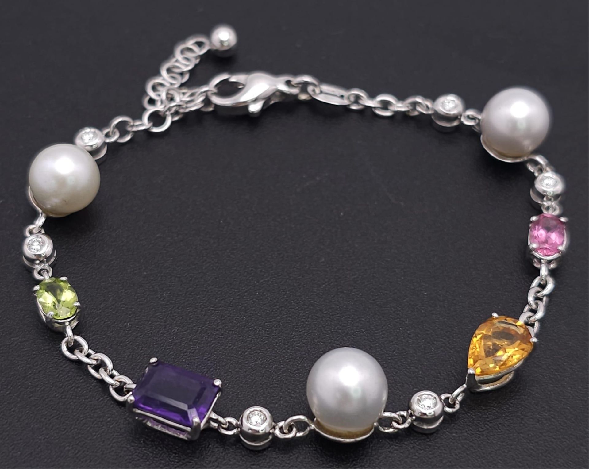 An 18 K white gold chain bracelet with a variety of gemstones (peridot, amethyst, citrine, etc)