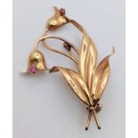 A 18K GOLD BROOCH IN FLORAL FORM WITH 2 PINK RUBY DECORATION . 4.4gms 5cms