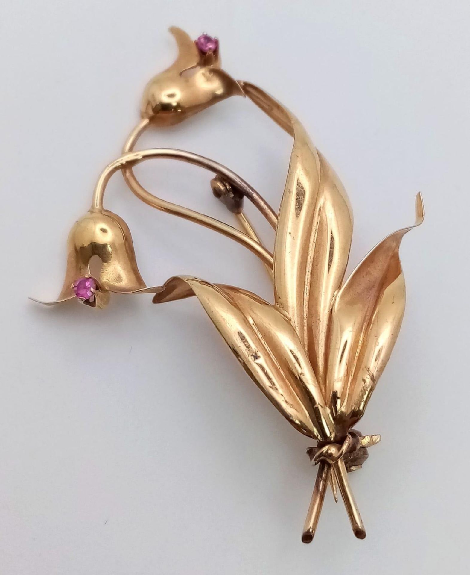 A 18K GOLD BROOCH IN FLORAL FORM WITH 2 PINK RUBY DECORATION . 4.4gms 5cms