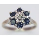 A 9 K yellow gold ring with a single diamond surrounded by six blue sapphires, size: M1/2, weight: