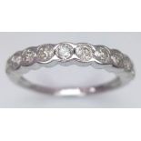 An 18 K white gold ring with a band of round cut diamonds, size: L1/2, weight: 1.9 g.