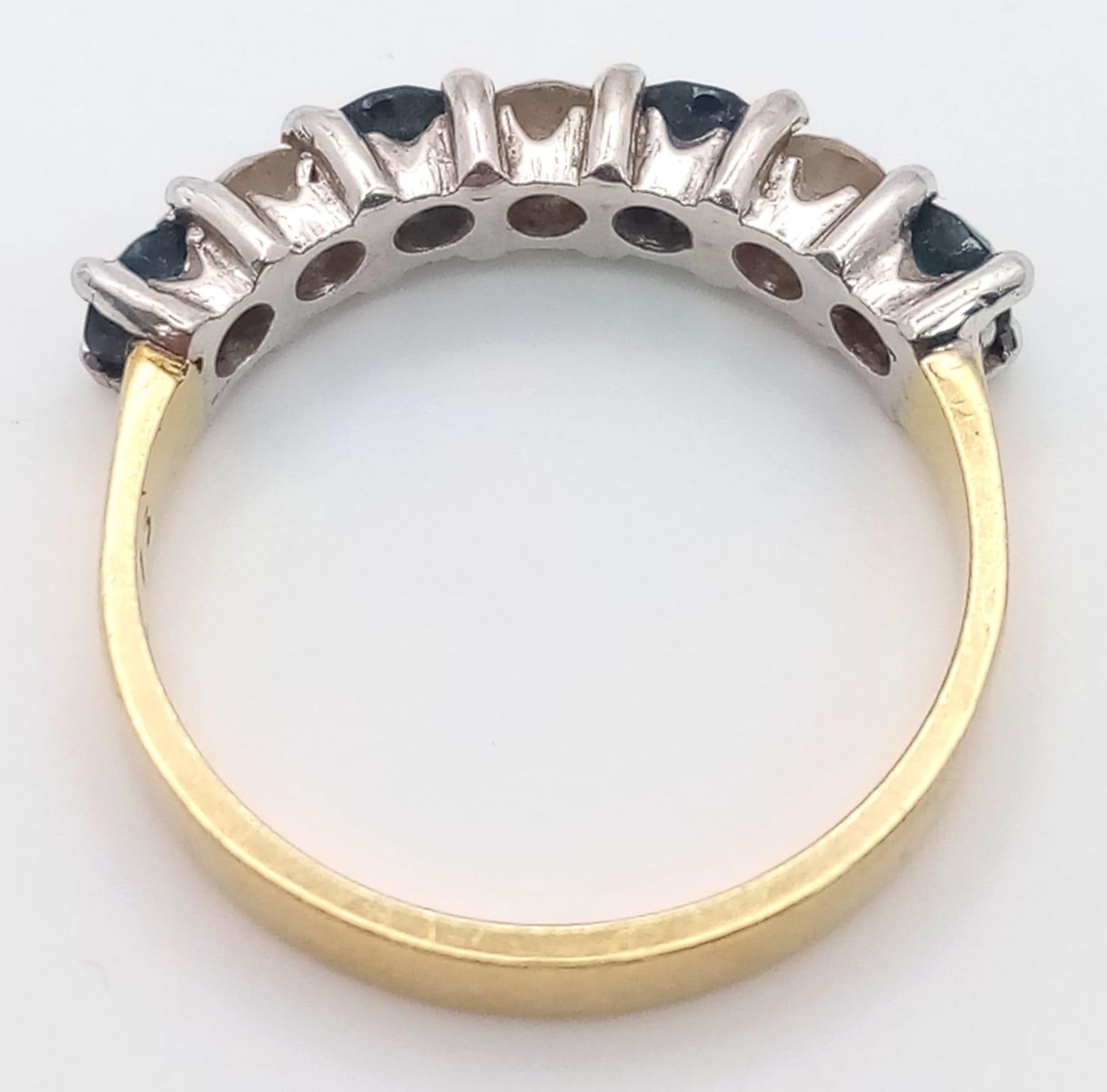 An 18 K yellow gold ring with a band of alternating round cut diamonds and blue sapphires. Size: - Image 3 of 4