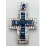 An 18 K white gold cross with blue baguette cut sapphires and round cut cubic zirconia,