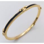 A gold plated, TROY BURCH design, black enamelled bangle. Clasp not tight. Inner dimensions: 59 x 50
