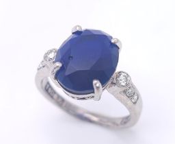 An 18K White Gold Sapphire and Diamond Ring. Central 3ct sapphire with diamond accents. Size M. 4.