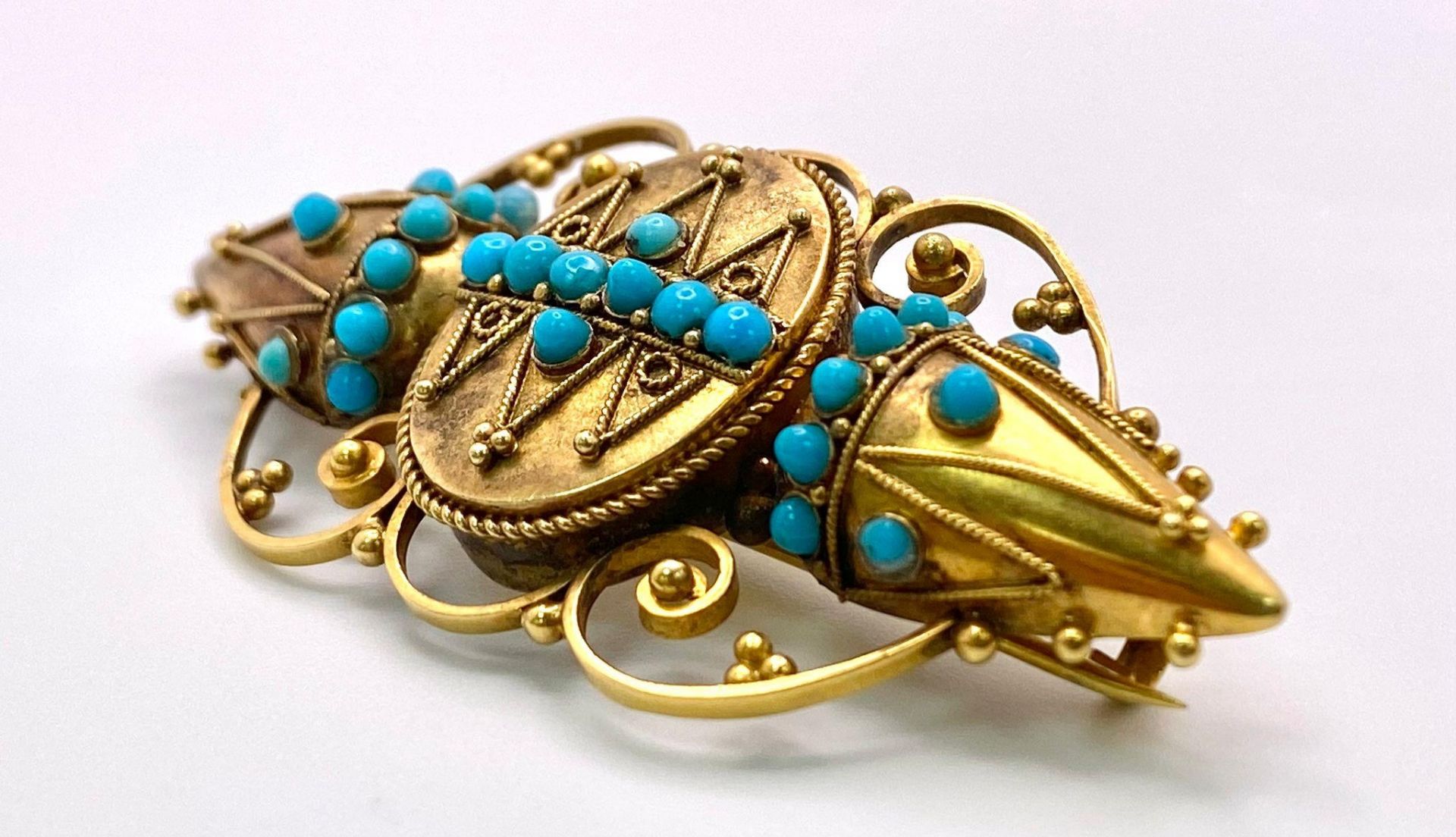 An Antique, Victorian 15K Gold and Turquoise Brooch. Scrolled and mirrored decoration. 5.5cm. 8. - Image 2 of 3