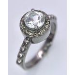 A Green Amethyst and Diamond Ring set in 925 Silver. Central round cut amethyst with a diamond halo.