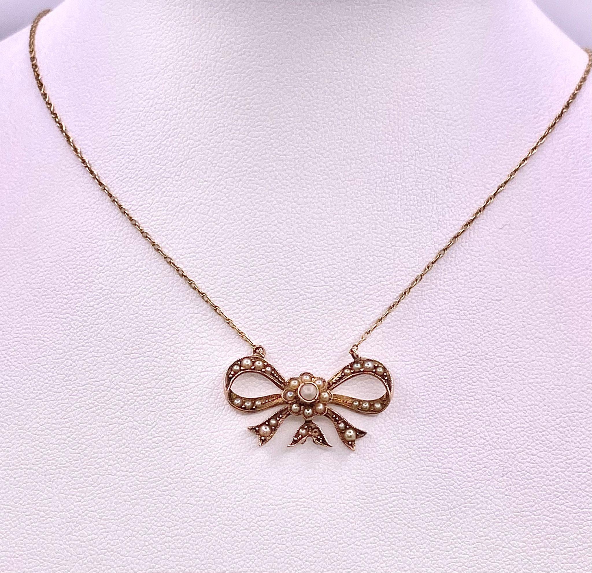 A 9KT Yellow Gold Necklace with a beautiful Bow, Pearl set Pendant. Measuring 50cm in length, this