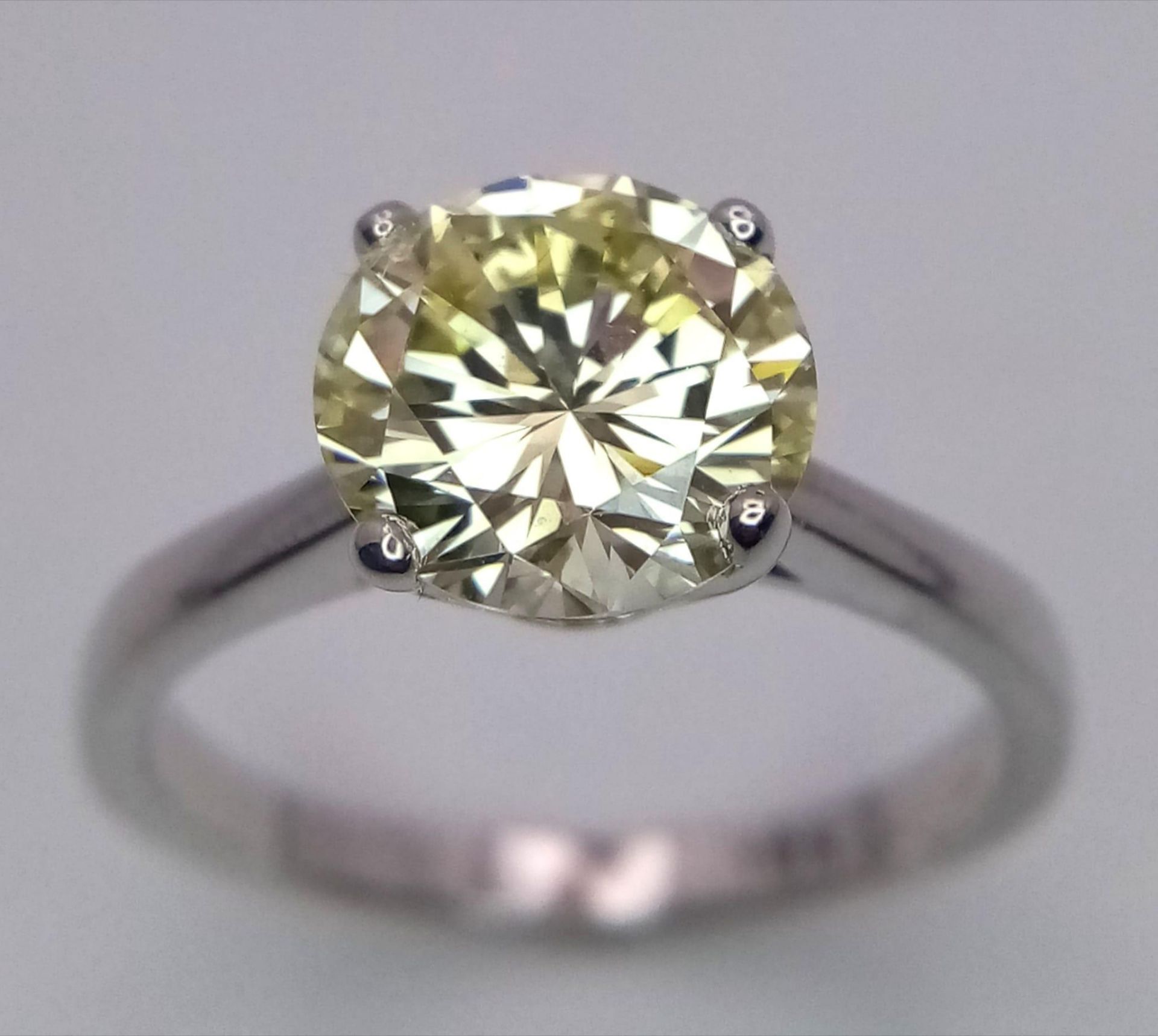 An 18K White Gold and 2.47ct VVS Yellow Diamond Ring. A brilliant round cut dancing centrepiece -