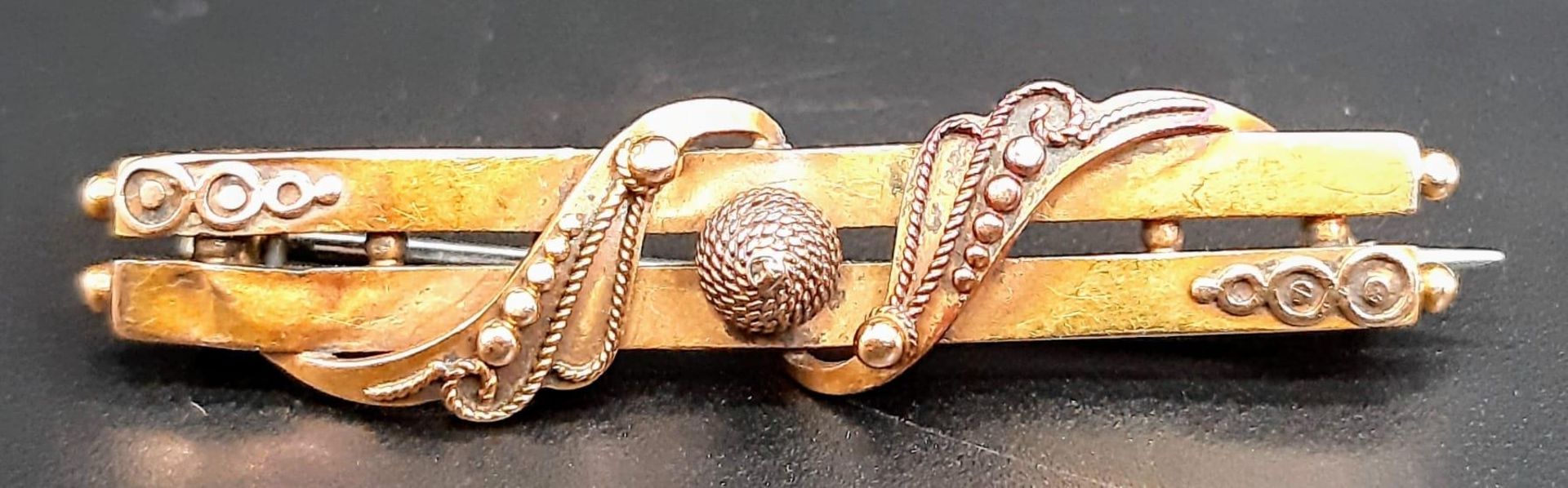 An Antique 15K Rose Gold Bar Brooch. Ornate decoration. Pin has been replaced. 4.5cm length. 3g