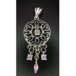 A 9K white gold diamond and pink sapphire circular articulated pendant, 2.7g, 4cm length (dia:0.