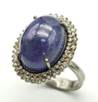 A 12ct Tanzanite Cabochon Gemstone ring with a 1.2ctw Double Diamond Halo. Set in 925 silver. Size