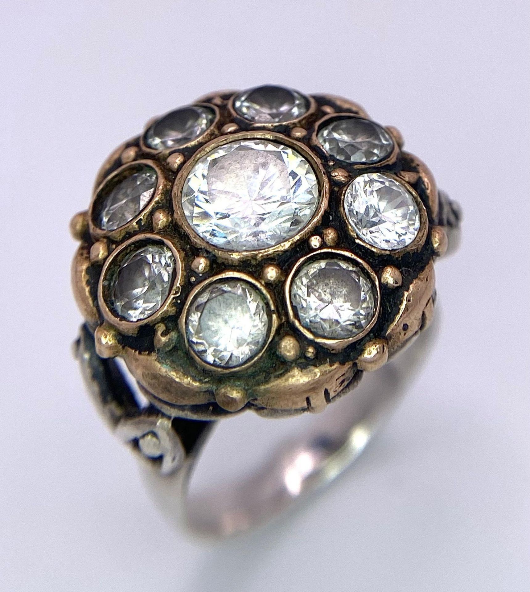 A 925 Silver Ring, with a fancy circular design adorned with white stones and interlaced with gold - Image 2 of 4