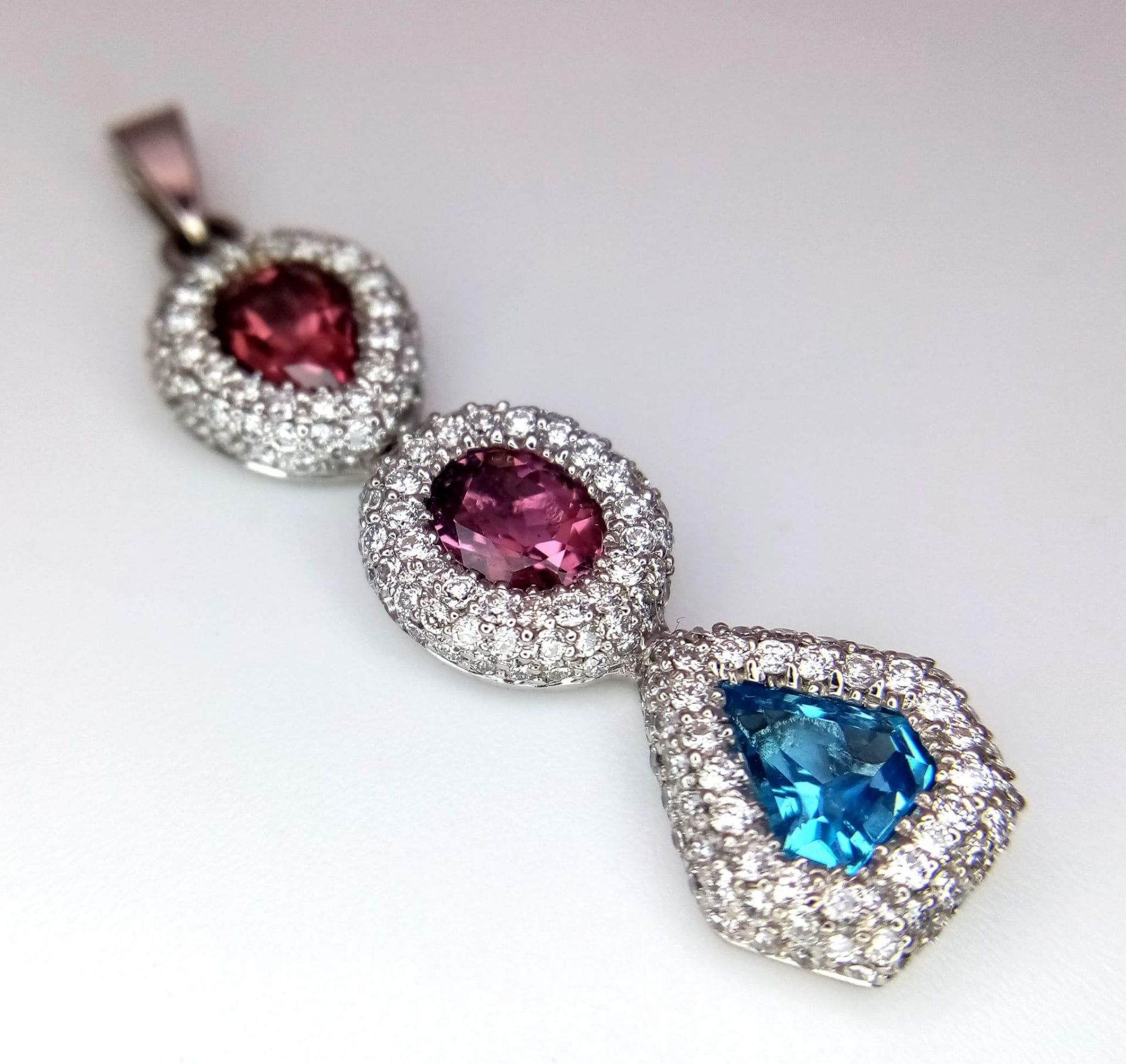 An 18K White Gold (tested) Ruby, Diamond and Topaz Drop Pendant. Three gemstones with diamond - Image 3 of 6