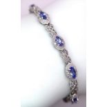 A 9K White Gold, Purple Sapphire and Diamond Tennis Bracelet. Eye-shaped links with sapphire