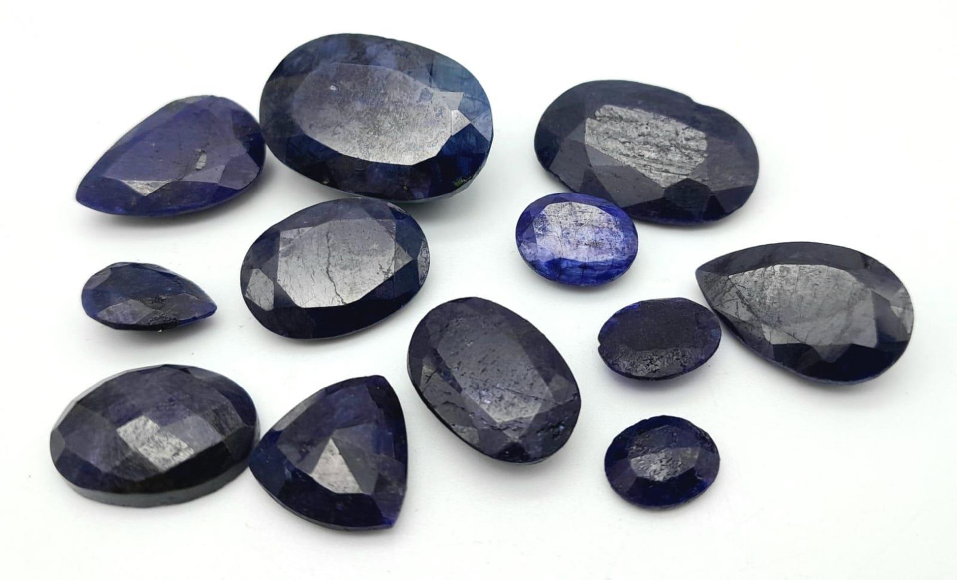 A 155.70ct Faceted Colour Enhanced Blue Sapphire Gemstone Lot - 12 Pieces, Mixed Shapes.