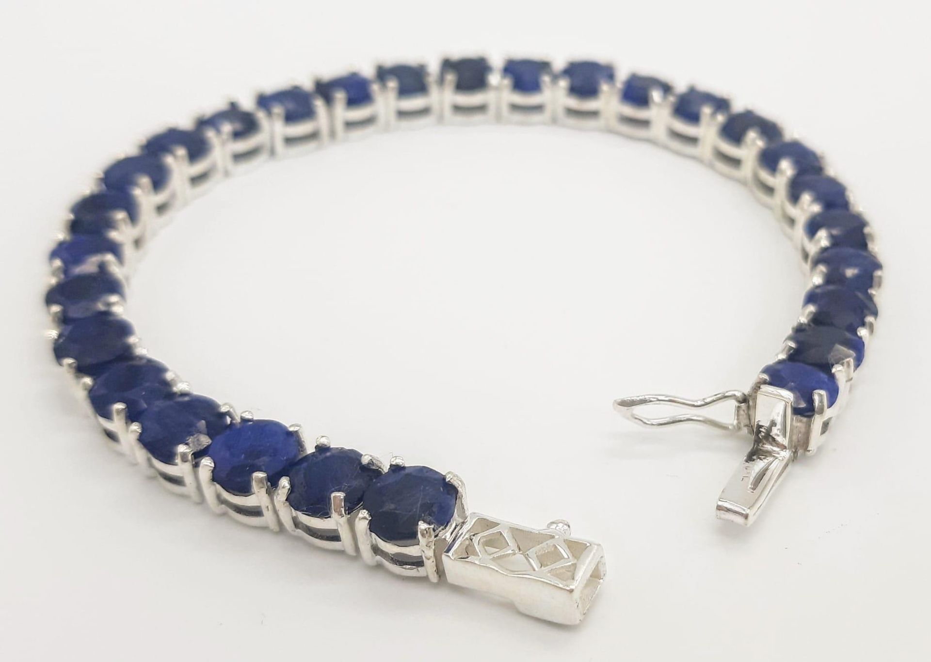 A Blue Sapphire Gemstone Tennis Bracelet set in 925 Silver. 18cm length. 19.75g total weight. Ref: - Image 3 of 5