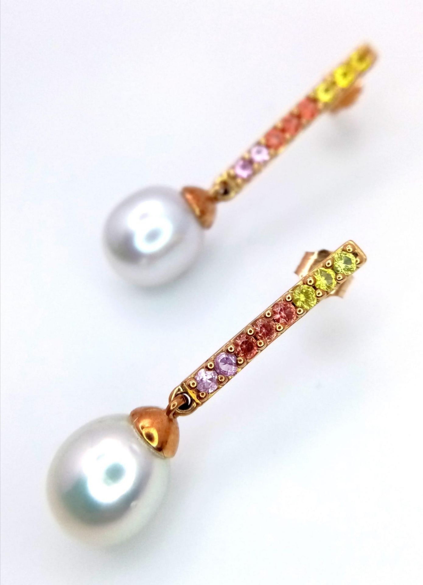 A Pair of 9K Yellow Gold South Sea Pearl and Multi-Coloured Sapphire Drop Earrings. Comes with a