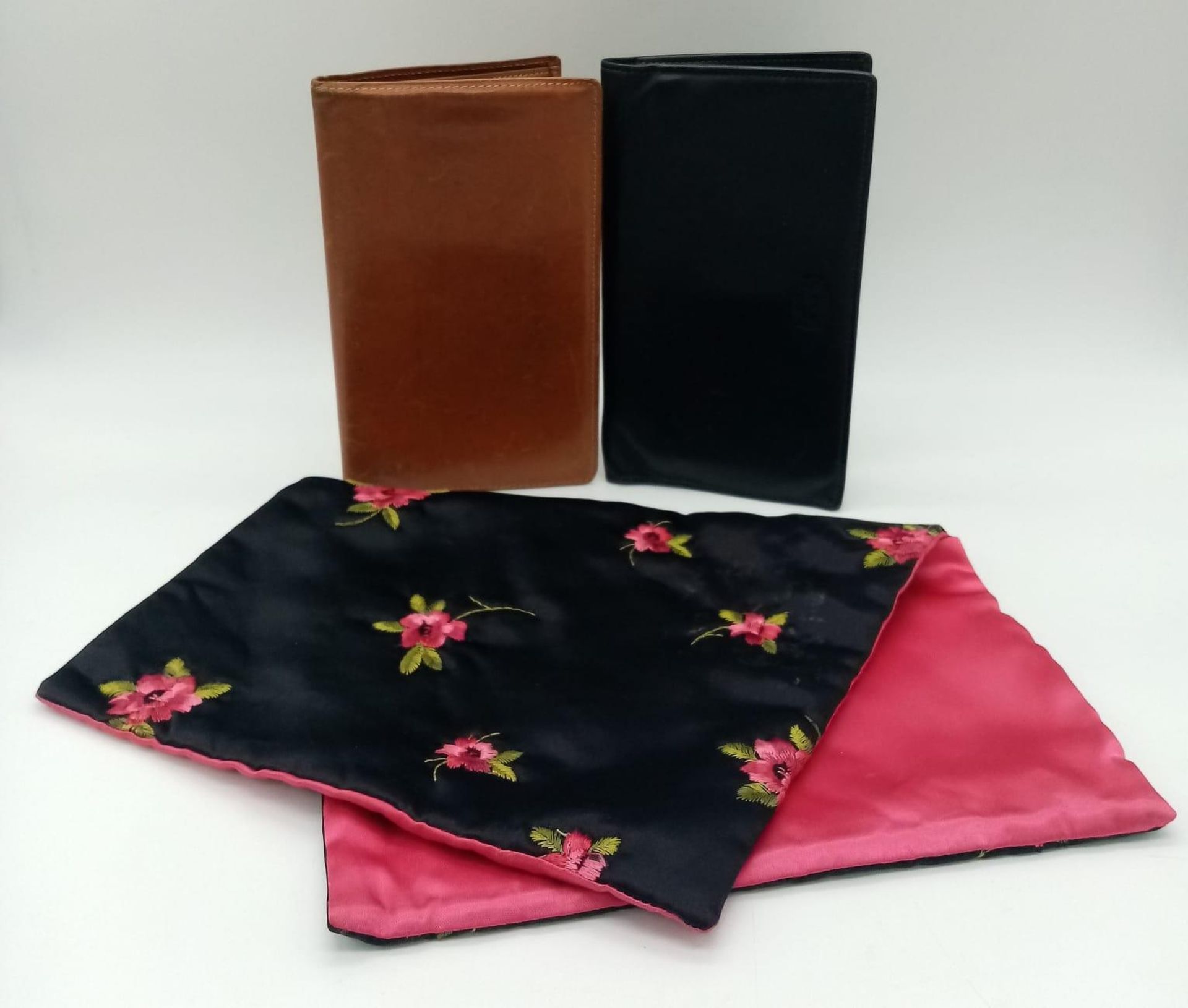 A collection of vintage designer leather wallets and a floral satin clutch. One Whitehouse Cox,