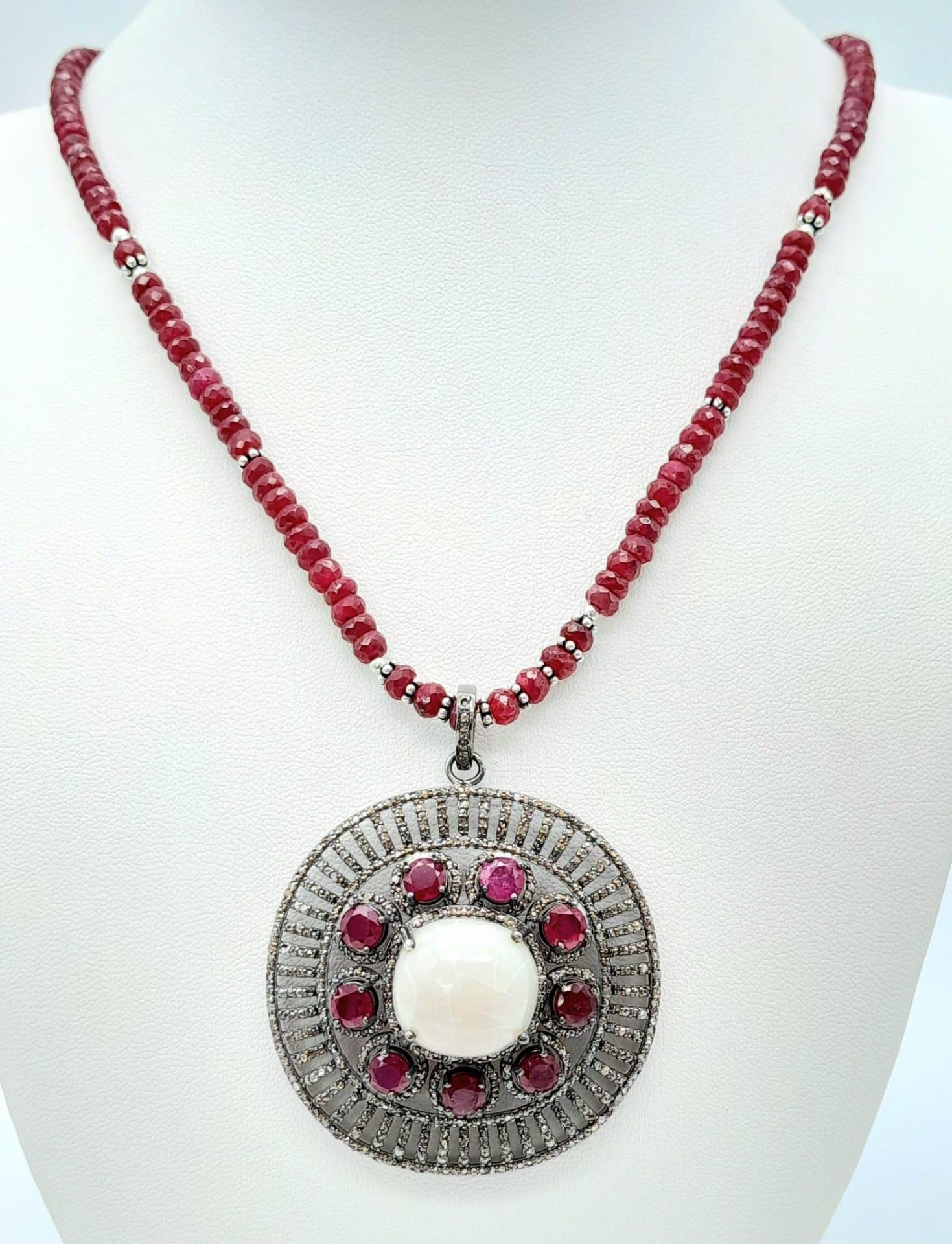 An Opal Pendant with Ruby and Diamond Surround on a Detachable Ruby Necklace. 16.5ct opal, 7.5ctw