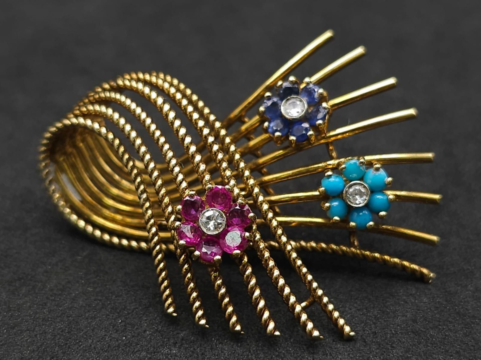 A 18kt Yellow Gold Woven Design Floral Brooch. Features three diamond centred flowers, which consist