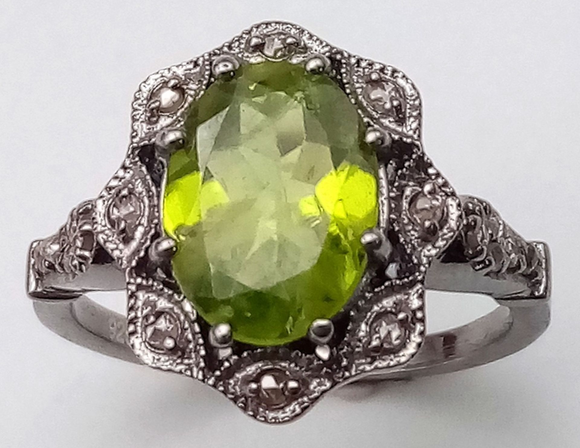 A Peridot and Diamond 925 Silver Ring. Central 2.50ct oval peridot with a diamond surround - 0. - Image 2 of 6