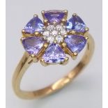 A 10K Yellow Gold Diamond and Tanzanite Floral Decorative Ring. Size R/S. 3.14g total weight.