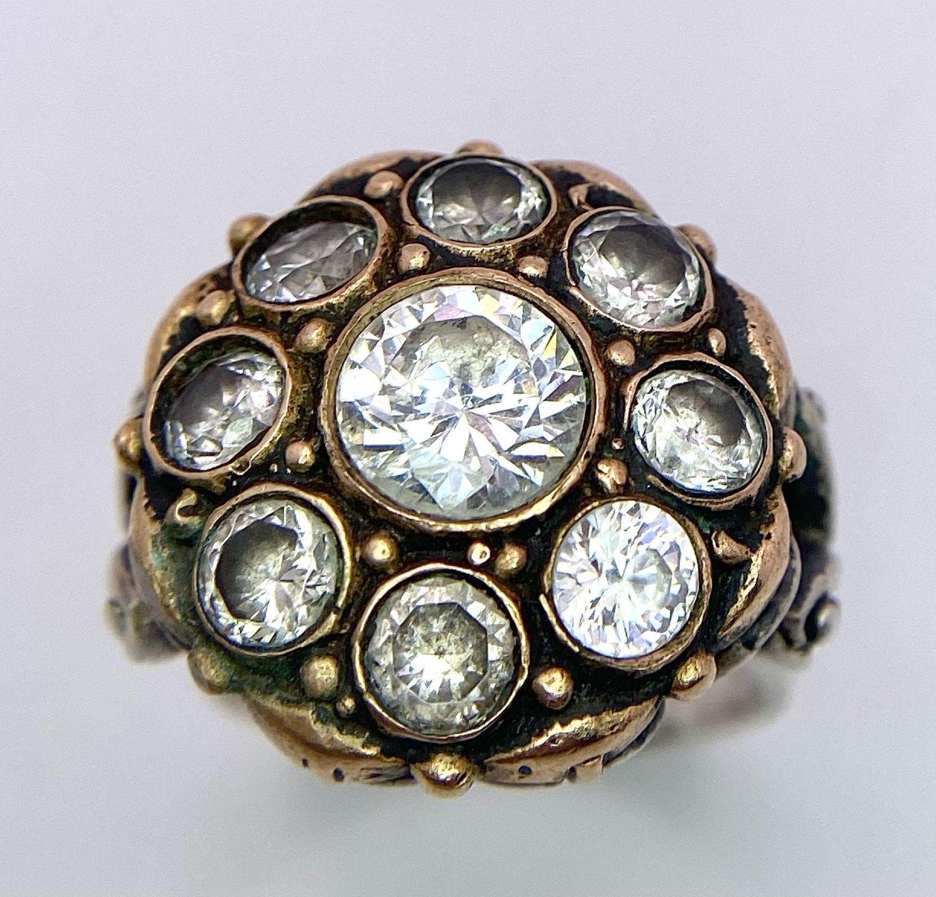 A 925 Silver Ring, with a fancy circular design adorned with white stones and interlaced with gold