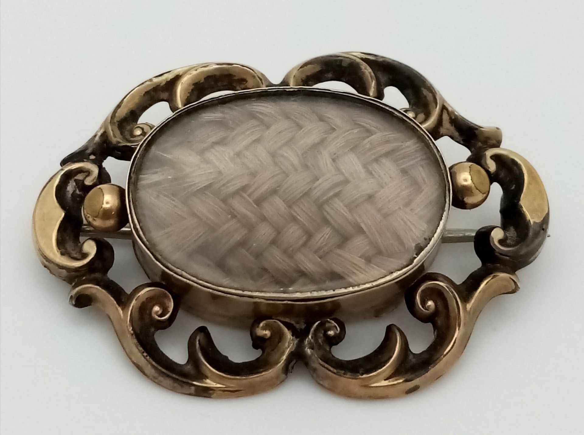 An Antique 9K Yellow Gold (tested) Memorial/Mourning Brooch. Hair encapsulation centre with a