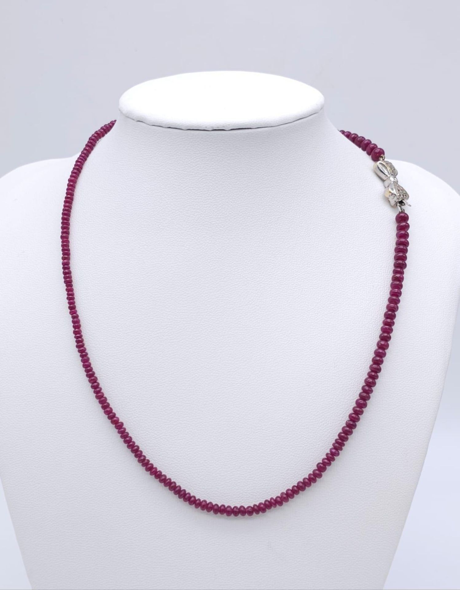 A superb graduating Ruby Red Stone Beaded Necklace with a 18kt White Gold, Diamond Set Bow Clasp. - Image 7 of 7