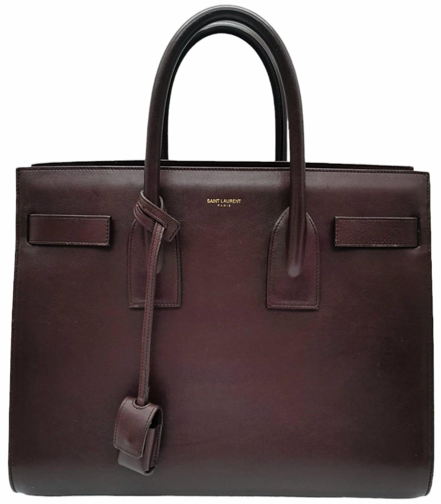 A Saint Laurent Sac De Jour Burgundy Handbag. Leather Exterior, Gold Tone Hardware, Double Handle in