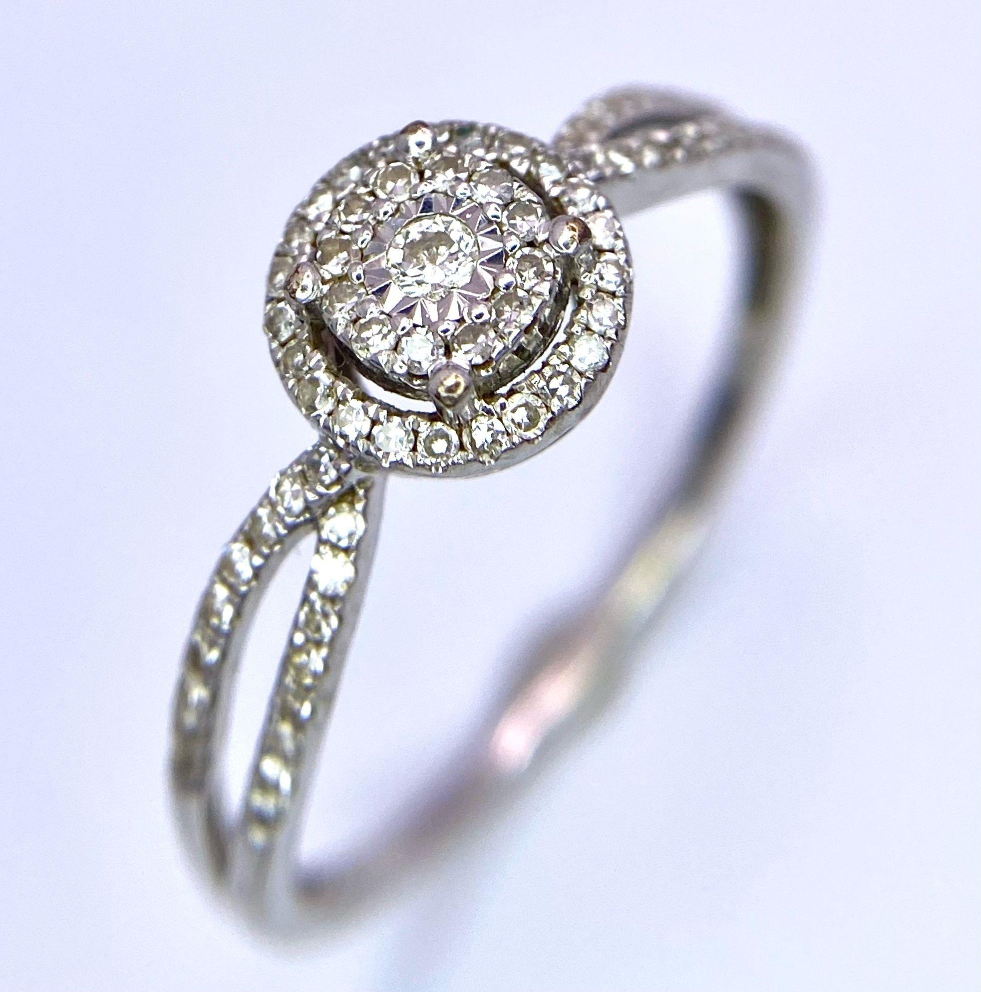 A 9K White Gold Diamond Double Halo Ring. Central diamond with double diamond halo and shoulder