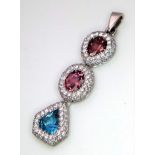 An 18K White Gold (tested) Ruby, Diamond and Topaz Drop Pendant. Three gemstones with diamond