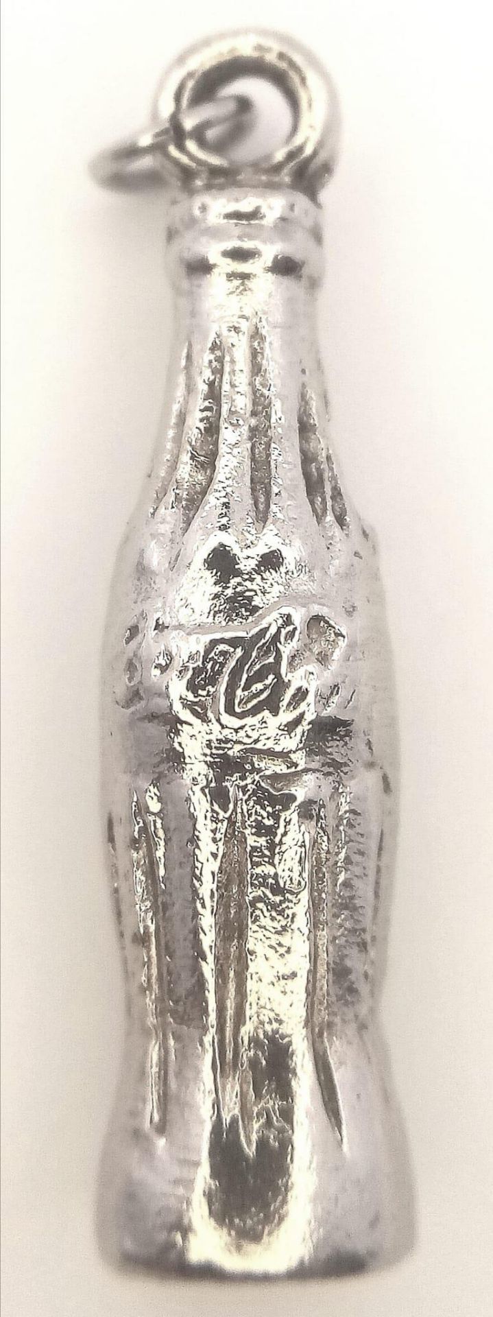 A White Metal Heavy Coca Cola Charm. 2.3cm length, 8.4g weight. Ref: SC 7087