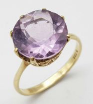 A 9K Yellow Gold Amethyst Ring. Round cut 6ct central amethyst. Size O. 3.2g total weight.