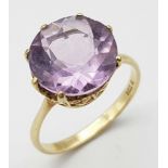 A 9K Yellow Gold Amethyst Ring. Round cut 6ct central amethyst. Size O. 3.2g total weight.