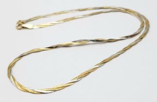 A Yellow and White Gold Intertwined Flat Necklace. Small kink so a/f. 40cm. 3g weight.